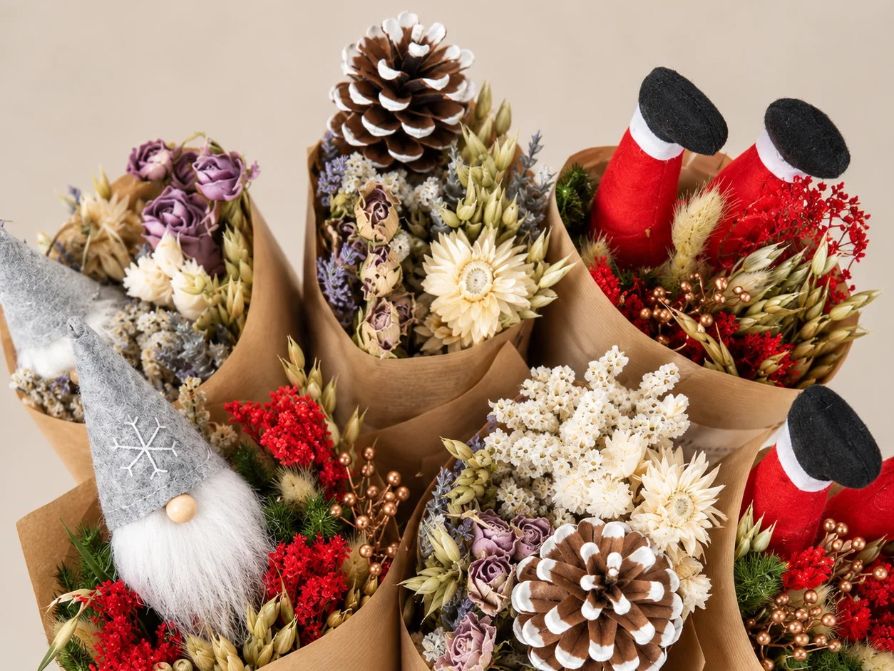 Christmas dried market bouquets with gnomes, Santa boots, pinecones, and red flowers in kraft paper wraps