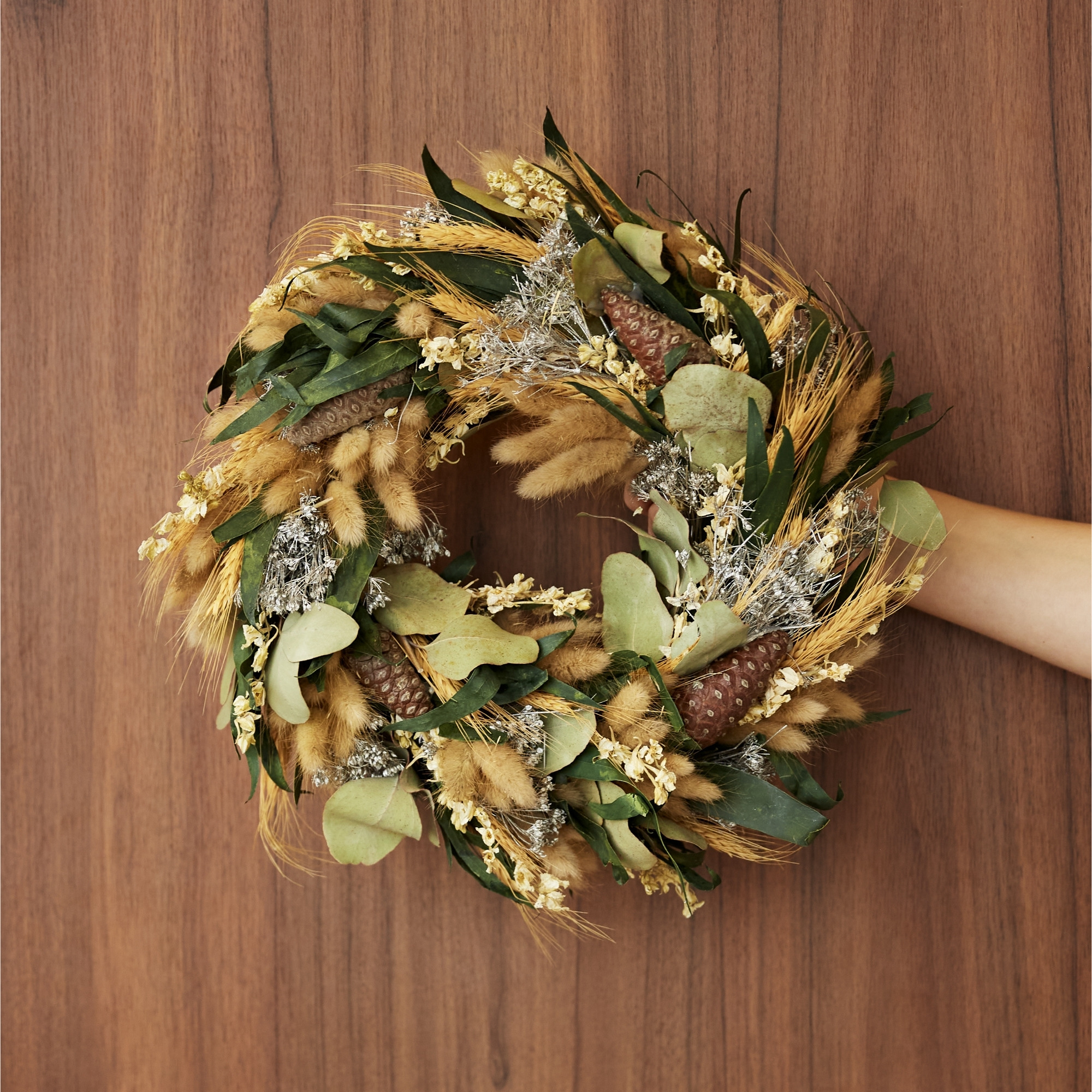 Dried wreath held against a wood background